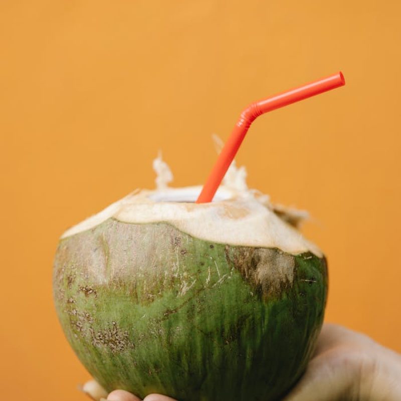 Crop woman with coconut cocktail