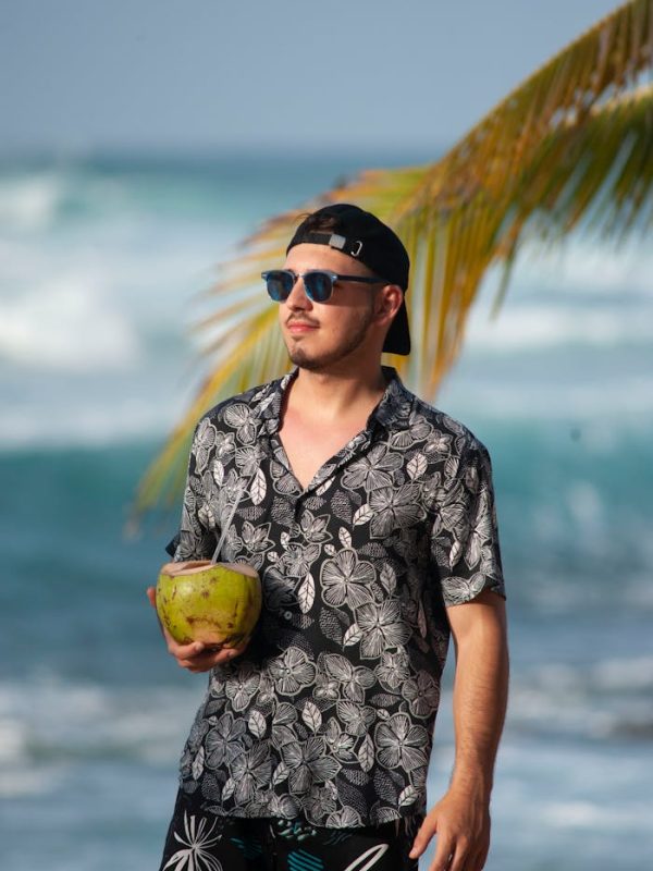 A Man Holding a Fresh Coconut in a Beach